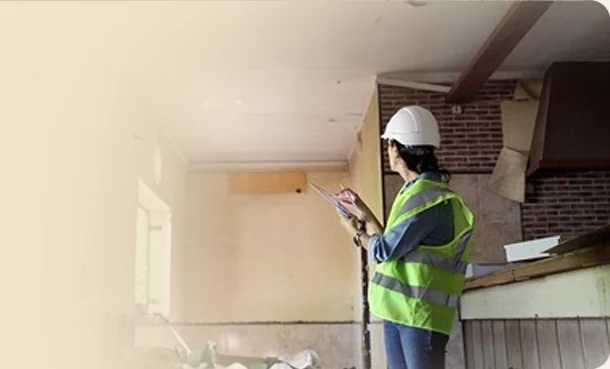 Surveyor in a hard hat inspecting a building interior